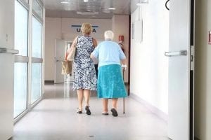 woman helping an elderly woman walk