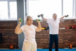 aging couple lifting weights